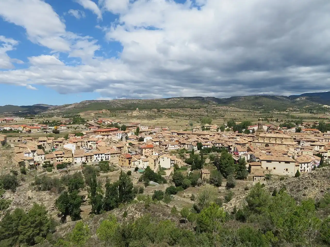 Mudanzas en Mora de Rubielos: vista del casco con los tejados, la torre de la iglesia y las montañas al fondo